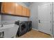 Functional laundry room with modern washer, dryer, and ample cabinet storage at 883 E Hampton Ln, Gilbert, AZ 85295