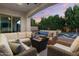 Inviting covered patio with comfortable seating, fire pit, and view of the sparkling pool and lush landscaping at 883 E Hampton Ln, Gilbert, AZ 85295
