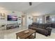 Comfortable living room featuring a plush sofa, entertainment center, and views of the dining area at 8912 N Johnson Ct, Maricopa, AZ 85139