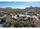 Aerial view of the property showcasing its desert setting, mountain views, and lush landscaping at 10010 E Blue Sky Dr, Scottsdale, AZ 85262