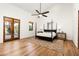 Bright bedroom with high vaulted ceilings, wood floors, ceiling fan and outdoor views through french doors at 10010 E Blue Sky Dr, Scottsdale, AZ 85262