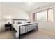 Bedroom featuring a metal frame bed, neutral carpet, window with blinds, and bedside lamps creating a cozy atmosphere at 10010 E Blue Sky Dr, Scottsdale, AZ 85262