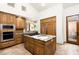 A chef's kitchen is enhanced with natural stone countertops, stainless steel appliances, and travertine flooring at 10010 E Blue Sky Dr, Scottsdale, AZ 85262