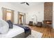 This spacious main bedroom offers hardwood floors, a stone fireplace, and two cozy chairs for lounging at 10010 E Blue Sky Dr, Scottsdale, AZ 85262
