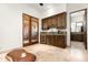 An elegant wet bar with wood cabinetry and granite countertops adjacent to an outdoor patio area at 10010 E Blue Sky Dr, Scottsdale, AZ 85262