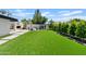 The expansive backyard offers lush artificial turf and a tranquil retreat, complemented by a built-in outdoor fireplace at 101 E Linger Ln, Phoenix, AZ 85020
