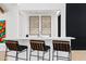 Close-up view of the wet bar, featuring a white countertop, three bar stools, and decorative accents at 101 E Linger Ln, Phoenix, AZ 85020