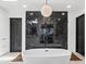 Bathroom featuring a modern soaking tub in front of a black marble tiled wall at 101 E Linger Ln, Phoenix, AZ 85020