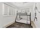 This is a modern bedroom featuring a bunk bed, plantation shutters, and light walls with a bold art accent at 101 E Linger Ln, Phoenix, AZ 85020