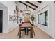 Bright dining room with wood beam ceiling, modern chandelier, wood table, and eclectic art at 101 E Linger Ln, Phoenix, AZ 85020