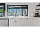Modern kitchen sink with a view of the backyard pool and sleek white countertops at 101 E Linger Ln, Phoenix, AZ 85020