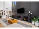 Open-concept living area with modern black fireplace, hardwood floors, and view to kitchen at 101 E Linger Ln, Phoenix, AZ 85020