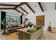 Bright living room with high ceilings, exposed beams, stylish furniture, and a large window showcasing the front yard at 101 E Linger Ln, Phoenix, AZ 85020