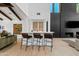 Bright open-concept living room featuring a bar, black brick fireplace, and exposed wood beam ceiling at 101 E Linger Ln, Phoenix, AZ 85020