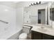 Well-lit bathroom with a bathtub, vanity, and a large mirror reflecting the shower area at 10242 N 66Th Ave, Glendale, AZ 85302