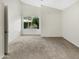 Bright bedroom with neutral carpet, featuring a window view of the outside landscape at 10242 N 66Th Ave, Glendale, AZ 85302