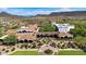 Expansive aerial view of a desert community with lush landscaping, fountain, and a red tile-roofed building at 12725 W Forest Pleasant Pl, Peoria, AZ 85383