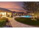 Landscaped backyard with pool, grassy area, and outdoor seating on a stone patio at 12725 W Forest Pleasant Pl, Peoria, AZ 85383