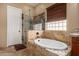 Bathroom featuring a separate tub and shower, and earthy toned tile at 12725 W Forest Pleasant Pl, Peoria, AZ 85383