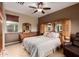 Spacious bedroom with a ceiling fan, tiled floors, and a luxurious king-size bed at 12725 W Forest Pleasant Pl, Peoria, AZ 85383