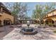 Beautiful courtyard with a central fountain, mature trees, and seating areas at 12725 W Forest Pleasant Pl, Peoria, AZ 85383