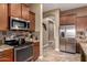 Well-equipped kitchen featuring stainless steel appliances, granite counters, and dark wood cabinets providing ample storage space at 12725 W Forest Pleasant Pl, Peoria, AZ 85383