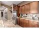 Spacious kitchen featuring dark wood cabinetry, granite countertops, stainless steel appliances, and tile flooring at 12725 W Forest Pleasant Pl, Peoria, AZ 85383