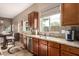 Bright kitchen features granite countertops, stainless steel appliances, and dark wood cabinets, seamlessly blending with the dining area at 12725 W Forest Pleasant Pl, Peoria, AZ 85383