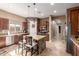 Modern kitchen featuring granite countertops, stainless steel appliances, a large island, and dark wood cabinetry at 12725 W Forest Pleasant Pl, Peoria, AZ 85383