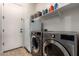 Laundry room showcases a washer, dryer, a mini fridge, and storage shelves above at 12725 W Forest Pleasant Pl, Peoria, AZ 85383