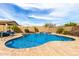 Backyard featuring a refreshing blue pool with beautiful stone accents and landscaping at 12725 W Forest Pleasant Pl, Peoria, AZ 85383