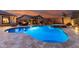 Inviting pool and spa with a fire pit lounge area, set against a dusk sky at 12725 W Forest Pleasant Pl, Peoria, AZ 85383