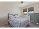 Well-lit bedroom with ceiling fan, natural light, and view of desert landscape at 18388 W Ida Ln, Surprise, AZ 85387