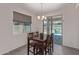 Bright dining area features a modern chandelier, window, and sliding glass door to the outdoor patio at 18388 W Ida Ln, Surprise, AZ 85387