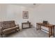 Functional office space with a comfy chair, display shelves, and a wooden desk with a laptop at 18388 W Ida Ln, Surprise, AZ 85387