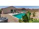 Backyard swimming pool with lounge chairs, blue umbrella, and desert landscaping creates a relaxing oasis at 18388 W Ida Ln, Surprise, AZ 85387