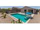 Outdoor pool area featuring a sparkling pool, desert landscaping, and a patio set for relaxing at 18388 W Ida Ln, Surprise, AZ 85387