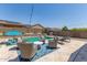 Inviting backyard pool area with comfortable seating and an umbrella for shade, perfect for relaxation at 18388 W Ida Ln, Surprise, AZ 85387