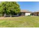 Large backyard with mature trees, patio seating and a grassy lawn at 18842 N Lakeforest Dr, Sun City, AZ 85373