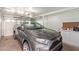 Well-lit garage with a gray SUV and storage cabinets along the back wall at 18842 N Lakeforest Dr, Sun City, AZ 85373