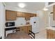 Functional kitchen featuring wood cabinetry, white appliances, and ample counter space at 18842 N Lakeforest Dr, Sun City, AZ 85373