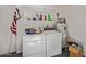 Functional laundry area with washer, dryer, shelving, and a water heater at 18842 N Lakeforest Dr, Sun City, AZ 85373
