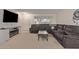 Comfortable living room featuring a plush sectional sofa, entertainment center, and carpeted floors at 18842 N Lakeforest Dr, Sun City, AZ 85373