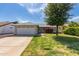 Single-story home featuring a two-car garage, green lawn, and manicured shrubbery under a blue sky at 19414 N 3Rd Ave, Phoenix, AZ 85027