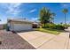 Charming single-story home with a two-car garage, green lawn, and manicured shrubbery under a blue sky at 19414 N 3Rd Ave, Phoenix, AZ 85027