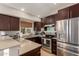 Modern kitchen features stainless steel appliances, granite countertops, and dark wood cabinets at 19414 N 3Rd Ave, Phoenix, AZ 85027