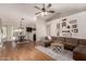 Open-concept living room and dining area with wood flooring, modern decor, and a ceiling fan at 19414 N 3Rd Ave, Phoenix, AZ 85027