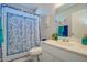 Bright bathroom with a patterned shower curtain, white vanity, and decorative accents at 19849 N 33Rd Ave, Phoenix, AZ 85027