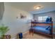 Cozy bedroom featuring a wooden bunk bed with blue bedding, a TV, and natural light at 19849 N 33Rd Ave, Phoenix, AZ 85027