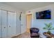 Bedroom showcasing closet space, a TV, a chair, and neutral walls at 19849 N 33Rd Ave, Phoenix, AZ 85027